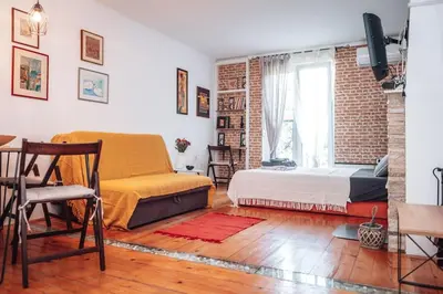 a bedroom with a bed and a brick wall at King Residences City Center in Belgrade