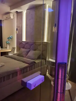 a bedroom with a bed with a purple light at Stan na dan PREMIUM 1 Obrenovac in Obrenovac
