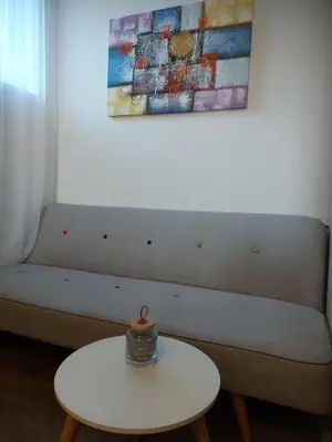 a white couch with a white table and a painting at Stan na dan PREMIUM 1 Obrenovac in Obrenovac