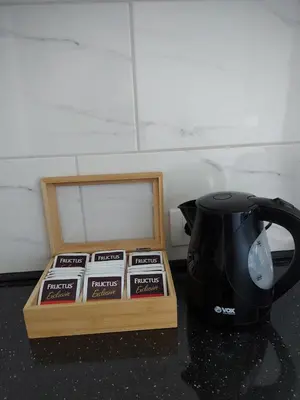 a black tea pot and tea packets next to a tea kettle at Stan na dan PREMIUM 1 Obrenovac in Obrenovac