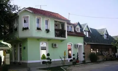 a large green house with at Apartments DANI in Skorenovac