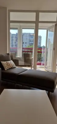 a living room with a couch and a large window at Sollemio in Novi Beograd