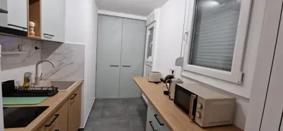 a kitchen with a counter with a sink and a microwave at Sollemio in Novi Beograd