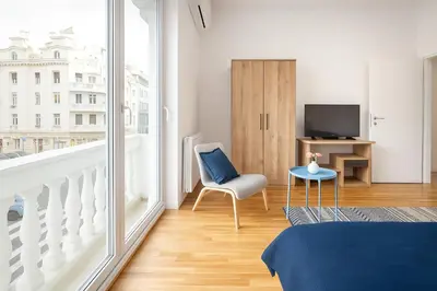 a bedroom with a bed and a chair and a television at 3 BDR for 6 CENTER CLOSE TO NATIONAL MUSEUM in Belgrade