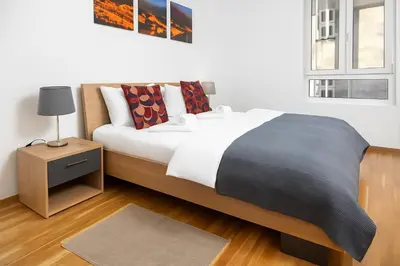a bedroom with a large bed and a night stand at 3 BDR for 6 CENTER CLOSE TO NATIONAL MUSEUM in Belgrade