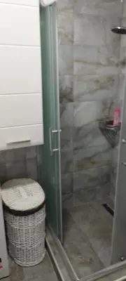 a bathroom with a shower with a trash can at apartman Elena in Zemun