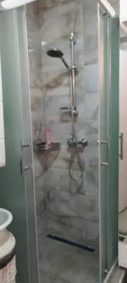 a shower with a glass door in a bathroom at apartman Elena in Zemun