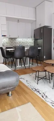 a living room with a table and black chairs at apartman Elena in Zemun