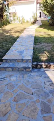 a stone walkway in a yard next to a house at apartman Elena in Zemun