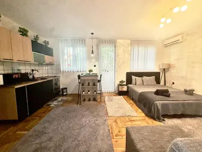 a bedroom with a bed and a kitchen with a table at Amazing apartman in Bele Vode in Bele Vode