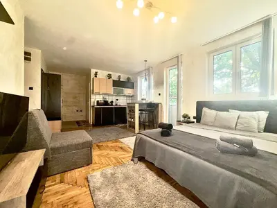 a bedroom with a large bed and a living room at Amazing apartman in Bele Vode in Bele Vode