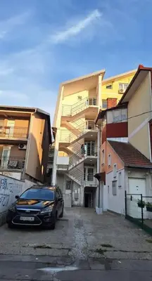 a car parked in a parking lot next to a building at Amazing apartman in Bele Vode in Bele Vode
