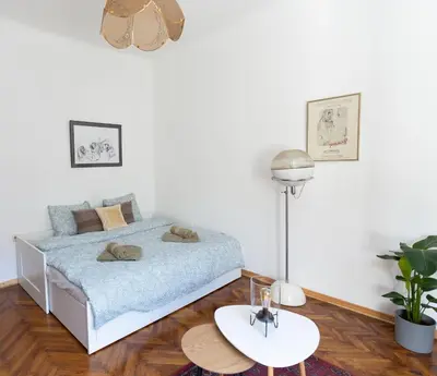 a white bedroom with a bed and a table at 85m large, bright and cozy Bona Apartment in Belgrade