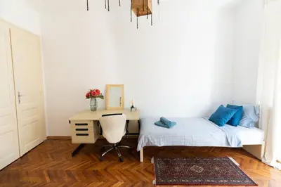 a bedroom with a desk and a bed and a chair at 85m large, bright and cozy Bona Apartment in Belgrade