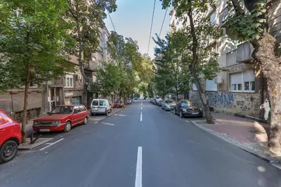 an empty street with cars parked on the sides of the road at 85m large, bright and cozy Bona Apartment in Belgrade