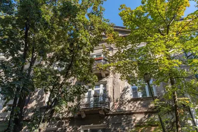 an apartment building with a balcony and trees at 85m large, bright and cozy Bona Apartment in Belgrade