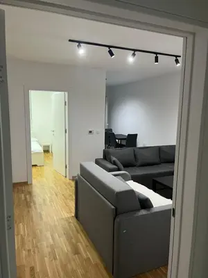 a living room with a couch and a room with a bed at Apartman Katarina in Pančevo