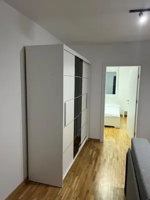 a bedroom with a large white closet and a bed at Apartman Katarina in Pančevo