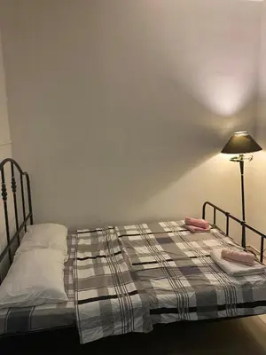 a bedroom with a bed with a blanket and a lamp at LEO Apartment in Belgrade
