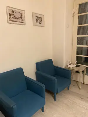 two blue chairs and a table in a room at LEO Apartment in Belgrade