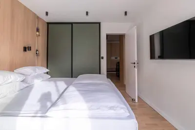 a bedroom with two white beds and a flat screen tv at HostGost Selected Suites - Skadarlija Artisan in Belgrade