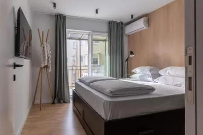 a bedroom with a bed and a large window at HostGost Selected Suites - Skadarlija Artisan in Belgrade