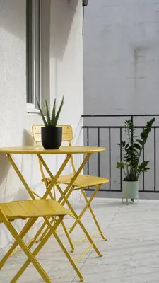 a yellow table and a yellow chair and a plant at HostGost Selected Suites - Skadarlija Artisan in Belgrade