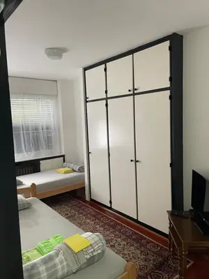 a bedroom with two beds and a large sliding glass door at Arena 23 in Novi Beograd