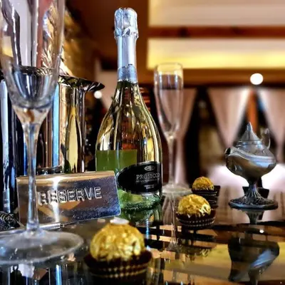a bottle of wine sitting on a table with cupcakes at Stone Spa Apartman in Sremčica