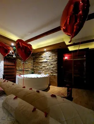 a room with balloons and a bath tub with hearts at Stone Spa Apartman in Sremčica