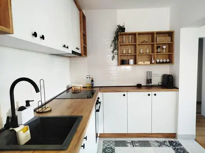 a kitchen with white cabinets and a sink at Apartman Alfa in Smederevo