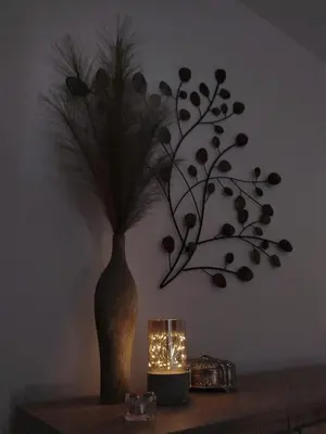 a vase with a plant on a table with a candle at Apartman Alfa in Smederevo