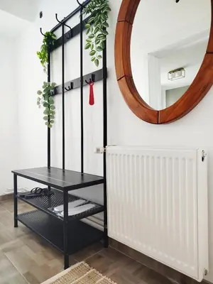 a mirror and a black table in a room with a shelf at Apartman Alfa in Smederevo