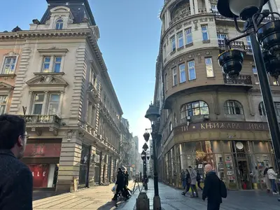 a city street with buildings and people walking on the street at Maison Danube in Belgrade