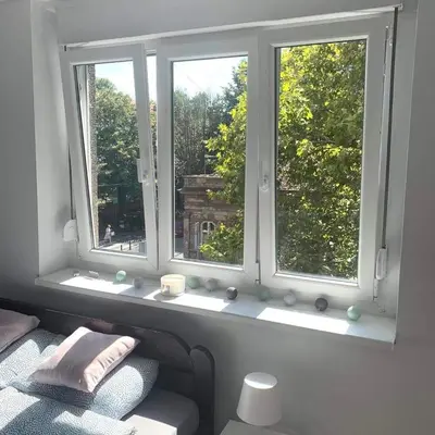 a room with two windows with a bed and a window sill at Apartman Vojvoda in Sajmište