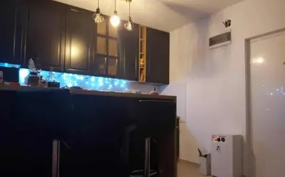 a kitchen with black cabinets and a blue counter top at Emilia Apartman in Ledine