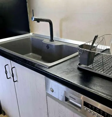 a kitchen sink with a faucet and a drying rack at Apartment 10 in Belgrade