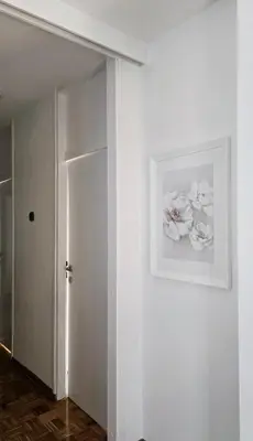 a white hallway with a picture of flowers on the wall at Apartment 10 in Belgrade