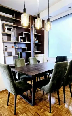 a dining room with a wooden table and green chairs at Apartment 10 in Belgrade