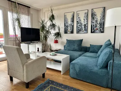 a living room with a blue couch and a tv at Apartment BLOK62 in Bežanija