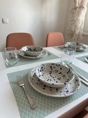 a table with plates and forks and glasses on it at Apartment BLOK62 in Bežanija