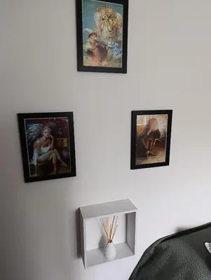 a room with four framed paintings on the wall at Apartment Square 59 Belgrade center in Belgrade