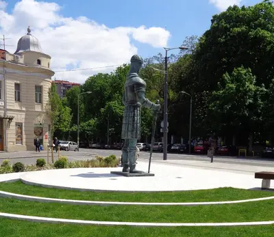 a statue of a man is standing in a park at Apartment Square 59 Belgrade center in Belgrade