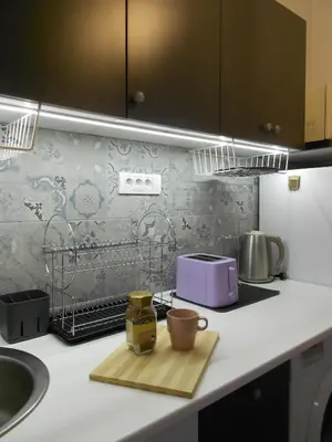 a kitchen counter with a toaster and cups on a cutting board at Apartment Square 59 Belgrade center in Belgrade