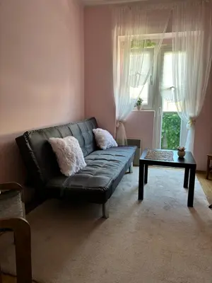 a living room with a black leather couch and a table at Kneginje Ljubice Apartment in Belgrade