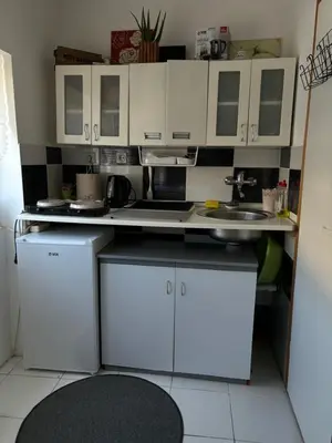 a small kitchen with white cabinets and a sink at Kneginje Ljubice Apartment in Belgrade