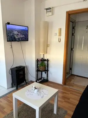 a living room with a table and a tv on the wall at Kneginje Ljubice Apartment in Belgrade