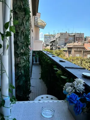 a balcony with a table and flowers on a ledge at Kneginje Ljubice Apartment in Belgrade