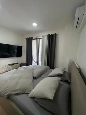 a bedroom with three beds with pillows and a flat screen tv at Belgrade Waterfront - Verde Studio in Sajmište