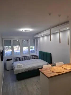 a bedroom with a bed and a table and some windows at Arena New Belgrade by Magenta in Novi Beograd